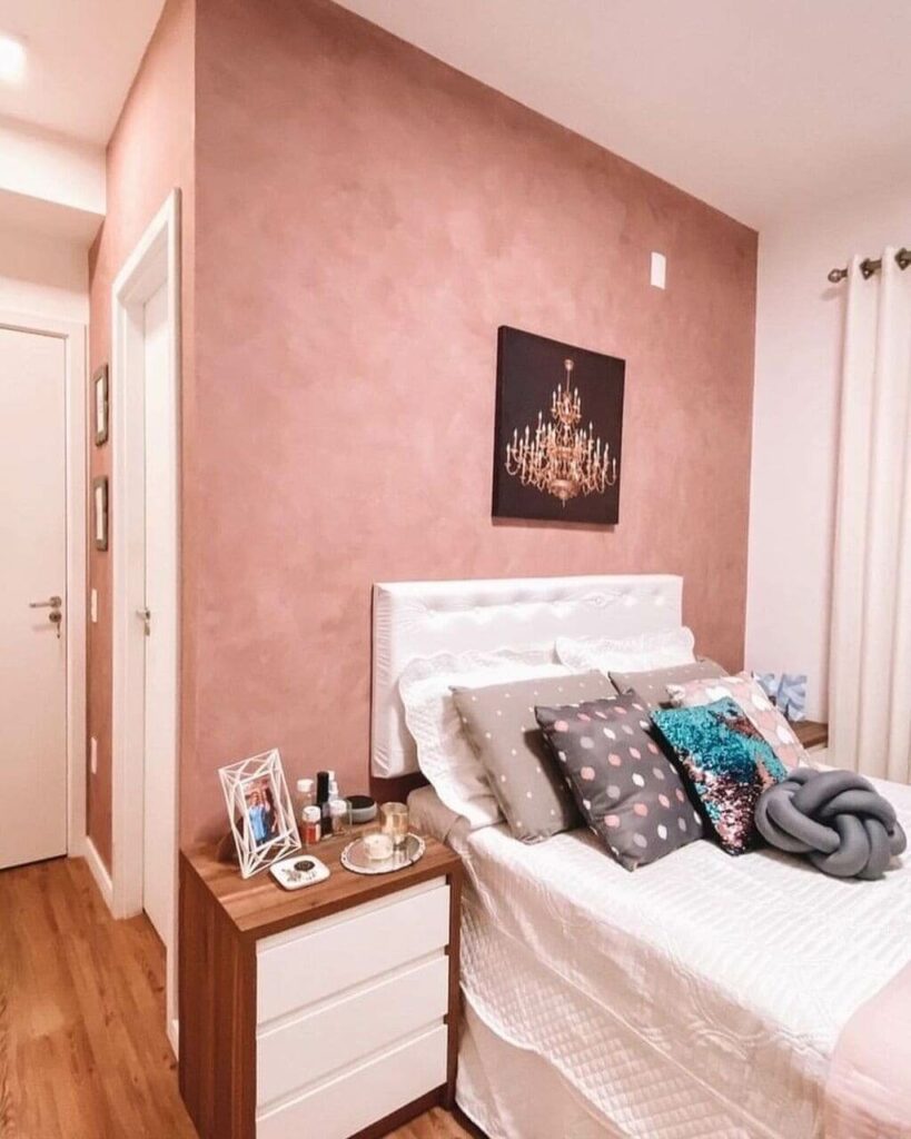 quarto com parede rosa queimado e cama com almofadas
