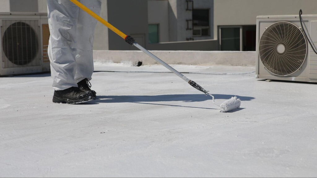 profissional usando rolo de pintura para fazer impermeabilização de telhado