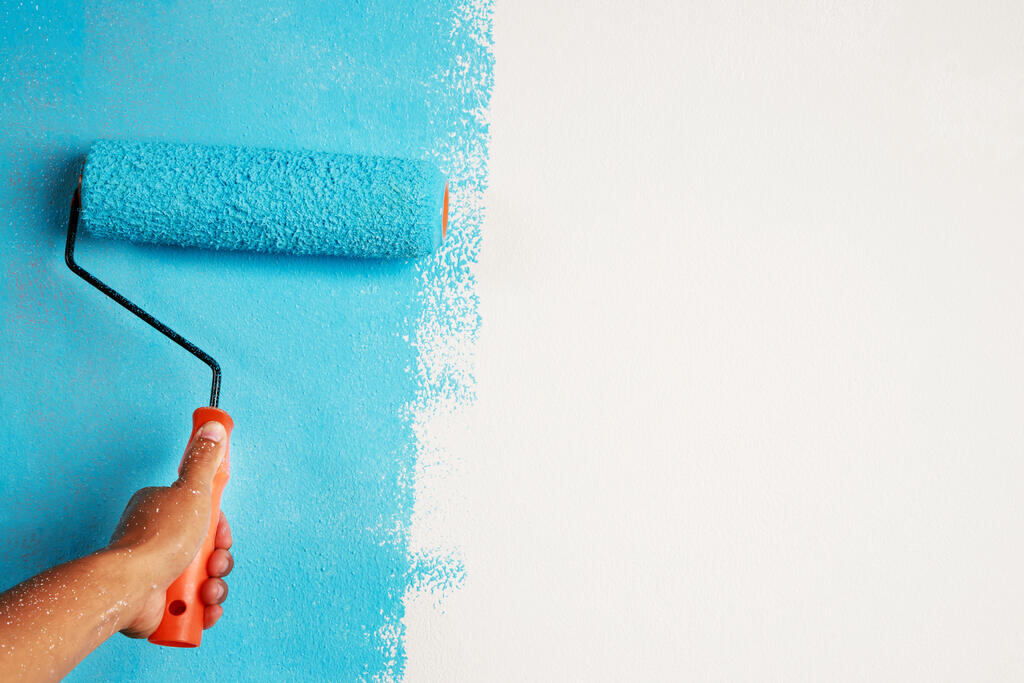 parede sendo pintada de azul com um dos tipos de tinta para parede